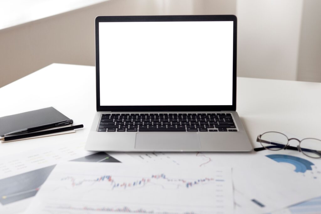 Financial documents arranged beside an open laptop for small business invoice processing
